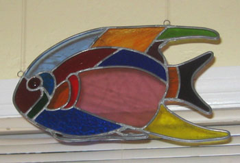 Stained glass fish hangs in the front window.