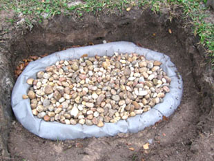 Washed river rocks fill the area within the drainage pipes.  Photo by Stibolt